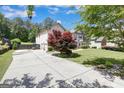 Long driveway leading to a two-car garage, accented by a beautiful red Japanese maple tree at 465 Harris Dr, Conyers, GA 30012