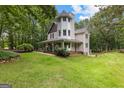 Charming two-story home with a inviting wraparound porch and well-maintained lawn at 135 Birdsong Ln, Fayetteville, GA 30215