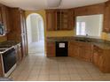 Spacious kitchen featuring granite countertops, oak cabinetry, and tile floors at 9160 Woodhaven Way, Mcdonough, GA 30253