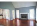 Bright living room featuring a stone fireplace, hardwood floors, and ample natural light at 74 Flanders Ct, Douglasville, GA 30134