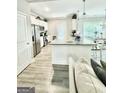 Open kitchen with stainless steel appliances and a granite countertop at 7728 Fawn Cir, Covington, GA 30014