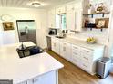 Bright kitchen featuring stainless steel appliances, white cabinetry, quartz countertops, and open shelving at 3095 Holbrook Sw Dr, Marietta, GA 30060