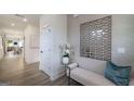 Bright, modern hallway with wood floors, white doors, and a stylish accent wall with decorative mirror and bench at 1818 Butterfly Way, Marietta, GA 30066