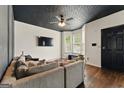 Cozy living room with natural light from bay windows, a comfortable sofa, and sleek black accents at 1689 Camden Forrest Way, Riverdale, GA 30296