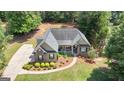 An aerial view showcases the home's beautiful landscaping, charming porch, and verdant surroundings at 150 Cold Harbor Ct, Sharpsburg, GA 30277