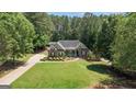 An aerial view of a well-maintained home with lush greenery and a long, private driveway at 150 Cold Harbor Ct, Sharpsburg, GA 30277