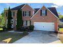 Charming brick two-story home with an attached two-car garage and manicured landscaping at 5678 Mill View Way, Lithonia, GA 30038