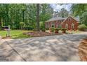 Spacious driveway leading to a brick home surrounded by lush greenery at 111 Biltmore Trce, Peachtree City, GA 30269