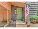 Charming front entrance with a covered porch, light-green door, and a patriotic American flag at 29 Clark Pl, Whitesburg, GA 30185
