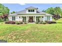 Charming home with a manicured lawn, rocking chair front porch, and inviting curb appeal on a sunny day at 377 Parker Rd, Mcdonough, GA 30252