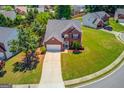 Aerial view of a beautiful brick home with a well-maintained lawn, driveway, and surrounding neighborhood at 2990 Haynes Club Cir, Grayson, GA 30017