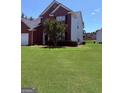 Charming two-story brick home with manicured front lawn and partial view of back yard at 2990 Haynes Club Cir, Grayson, GA 30017