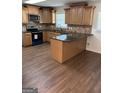 Updated kitchen featuring granite counters, stainless steel appliances, island, and wood flooring at 113 Ausband Dr, Mcdonough, GA 30253