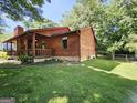 Side exterior view of home with wooden siding and ample backyard lawn space at 6698 Cameron Rd, Morrow, GA 30260
