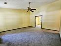 Spacious living room with neutral carpeting, ceiling fan and two doorways at 6698 Cameron Rd, Morrow, GA 30260