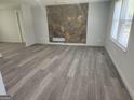 Bright living room featuring new flooring and a unique stone accent wall at 2615 Old South Ct, Jonesboro, GA 30236