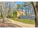 Beautiful home with gray roof and light yellow siding surrounded by mature trees and lush landscaping at 2366 Battle Forest Sw Dr, Marietta, GA 30064