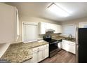 Well-lit kitchen featuring stainless steel appliances, granite countertops, and white cabinetry at 1901 Clarke Ln, Decatur, GA 30035