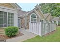 Close up exterior view of a home featuring stone accents, neat landscaping, and a white fence at 150 Butterton Ct, Fayetteville, GA 30214