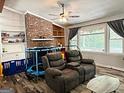 Cozy living room featuring a brick fireplace, hardwood floors, and large windows with natural light at 224 Potts Se Rd, Conyers, GA 30094