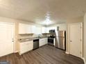 Kitchen featuring stainless steel appliances, white cabinets, granite counters and wood floors at 5405 Lakeside Dr, Union City, GA 30291