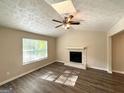 The sunlit living room features a stone fireplace, wood floors, and a ceiling fan at 5405 Lakeside Dr, Union City, GA 30291