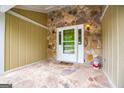 Inviting covered porch featuring stonework walls, a flagstone floor, and a white-framed glass storm door at 7358 S Mitchell Ct, Villa Rica, GA 30180