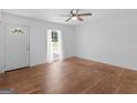 Bright living room with hardwood floors, ceiling fan, and a door leading to a verdant outdoor view at 1356 Lori Ct, Conley, GA 30288