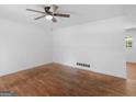 Bright living room with hardwood floors, a ceiling fan, and neutral walls, ideal for customization at 1356 Lori Ct, Conley, GA 30288