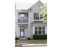 Townhouse featuring a brick facade, charming balcony, and well-maintained front yard at 7699 Cabrini Pl, Fairburn, GA 30213