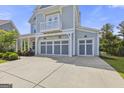 Attached three-car garage featuring decorative doors with a balcony overhead at 229 Widener Way, Peachtree City, GA 30269