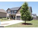 Beautiful exterior view of a two-story home with a lush green lawn and spacious driveway leading to the garage at 524 Harmony Way, Locust Grove, GA 30248