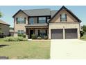 Inviting two-story home with a brick and siding exterior, complemented by a well-maintained lawn and landscaping at 524 Harmony Way, Locust Grove, GA 30248