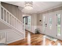 Inviting foyer with hardwood floors, white wainscoting, staircase, and stylish front door at 1478 Interlaken Pass, Jonesboro, GA 30238