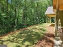 Expansive backyard features newly laid grass and the edge of a covered porch looking out to a treeline at 518 Paynes Lake Rd, Carrollton, GA 30116