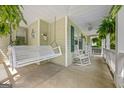 Inviting front porch with a swing, rocking chairs, decorative plants, and a ceiling fan for relaxed outdoor enjoyment at 229 Lafayette St, Locust Grove, GA 30248