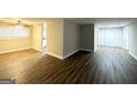 Open-concept living space featuring hardwood flooring with a view to the kitchen at 310 Flagstone Sw Dr, Atlanta, GA 30331