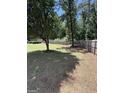 Spacious backyard featuring a wooden fence, mature trees, and a mix of grassy and shaded areas at 3005 Ryan Rd, Locust Grove, GA 30248