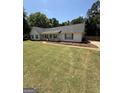 Inviting single-story home with manicured lawn, mature landscaping, and a cozy covered front porch at 3005 Ryan Rd, Locust Grove, GA 30248