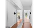 Bright hallway featuring hardwood floors and large mirrored closet, and views into other rooms at 3005 Ryan Rd, Locust Grove, GA 30248