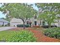 Beautiful two-story home featuring lush landscaping, brick accents, and an attached garage at 207 Tiverton Trl, Peachtree City, GA 30269