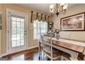 Dining room with hardwood floors, chandelier, decorative painting, and door to the backyard at 273 Prominent Loop, Mcdonough, GA 30253