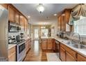 Well-lit kitchen with stainless steel appliances, wooden cabinets, and an island with a sink at 273 Prominent Loop, Mcdonough, GA 30253