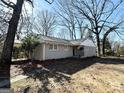 Inviting single-story home with neutral exterior, landscaped front yard, and mature trees around the property at 2896 Hogan Rd, East Point, GA 30344