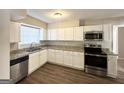 Well-lit kitchen with modern stainless steel appliances, granite countertops, and ample white cabinetry at 2896 Hogan Rd, East Point, GA 30344