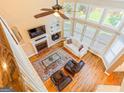 High-angle view of the bright living room with fireplace, large windows, and hardwood floors at 2810 Promenade Pl, Buford, GA 30519