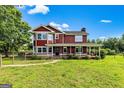 Attractive two-story home featuring a inviting front porch and a well-maintained green lawn at 68 Riveree Rd, Brooks, GA 30205