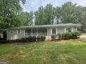 Charming single-story home features a welcoming front porch, fresh lawn and tidy landscaping at 6236 Shallow Creek Ln, Douglasville, GA 30135