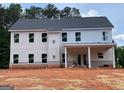 New home's back exterior features a covered patio, multiple windows, and brick foundation at 3292 Mill Forest Sw Dr, Conyers, GA 30094