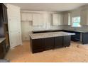 Bright kitchen boasts white and dark cabinets, granite countertops, and a central island at 3292 Mill Forest Sw Dr, Conyers, GA 30094